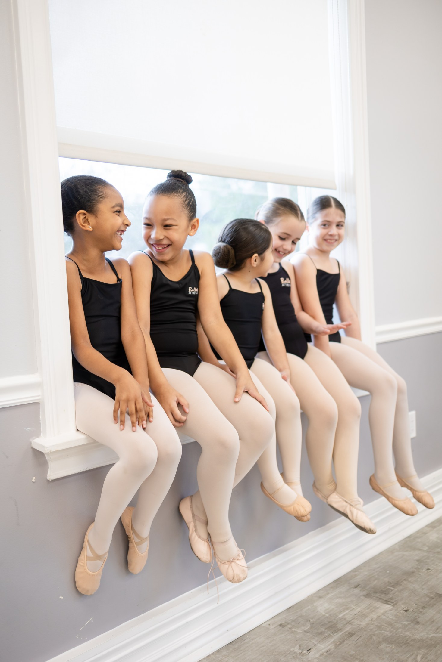 Young dancers seated at the studio window