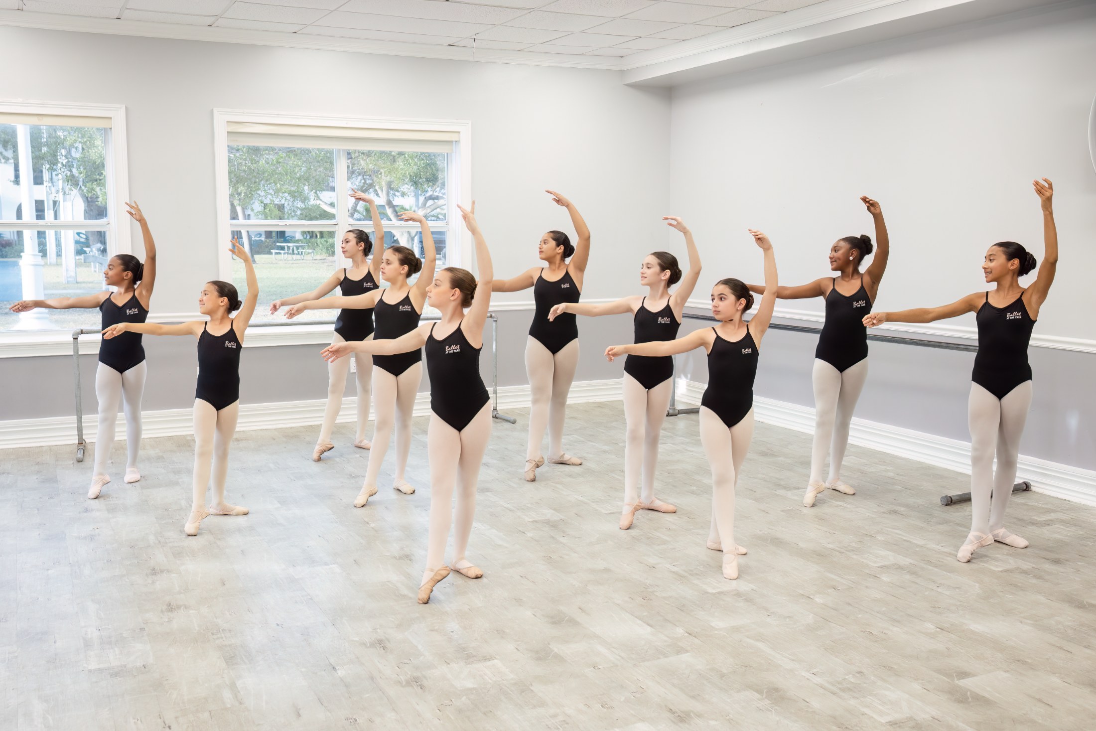 Class in port de bras across the studio floor